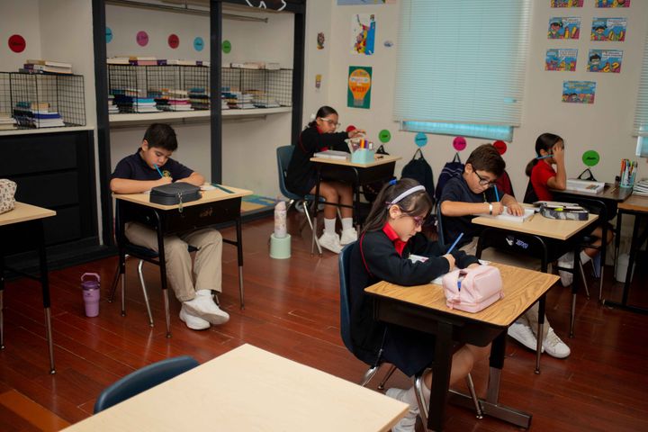 Alumnos concentrados en su trabajo en el aula